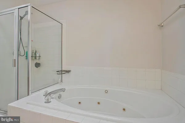 a white bath tub sitting next to a shower