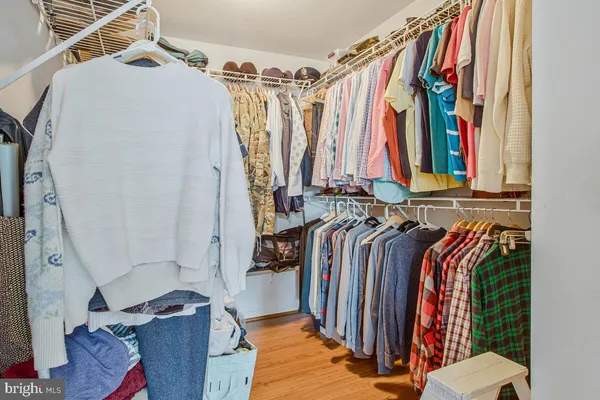 a view of walk in closet with clothes and shoes