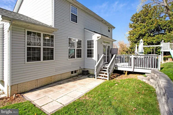 a view of a house with a deck and a yard
