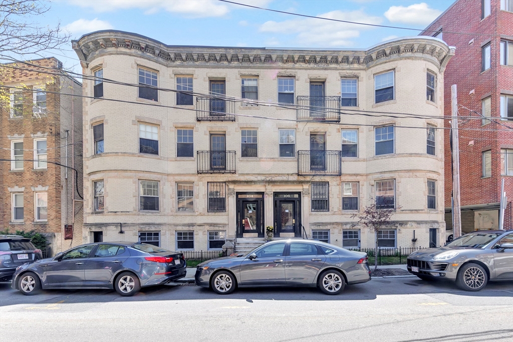a front view of a residential apartment building with parking space