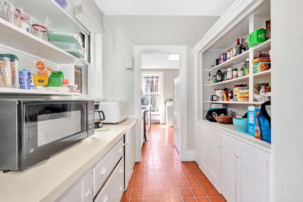 104 Strathmore Road Boston, MA 02135 - Photo 11 of 41 a kitchen with stainless steel appliances granite countertop a lot of counter top space and wooden floor