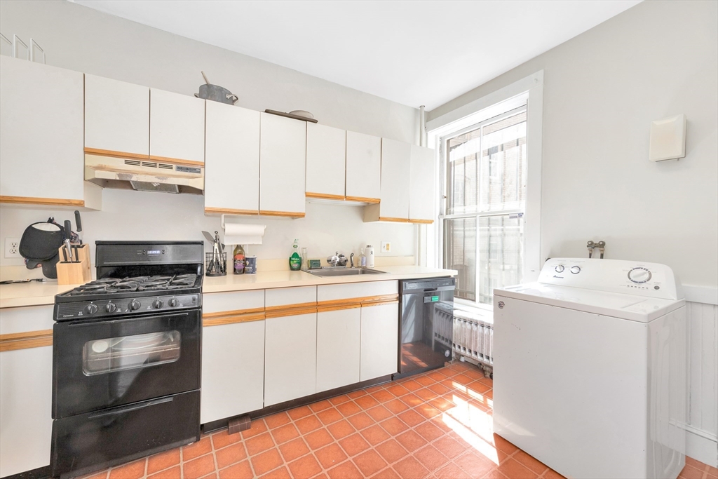 104 Strathmore Road Boston, MA 02135 - Photo 13 of 41 a kitchen with a stove a sink and a refrigerator