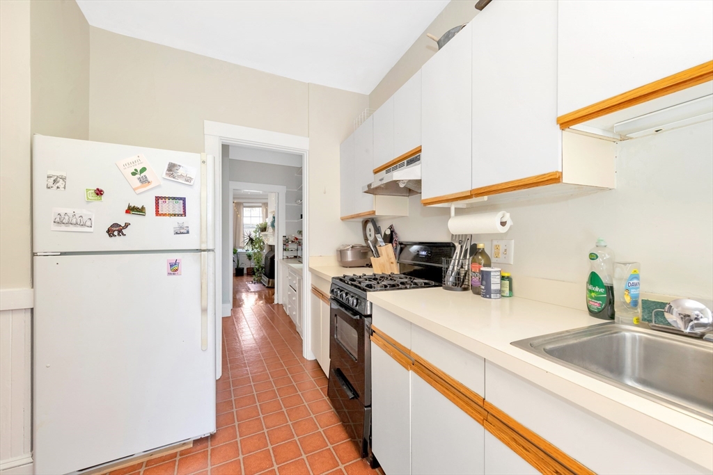 104 Strathmore Road Boston, MA 02135 - Photo 14 of 41 a kitchen with a sink a refrigerator and wooden floor