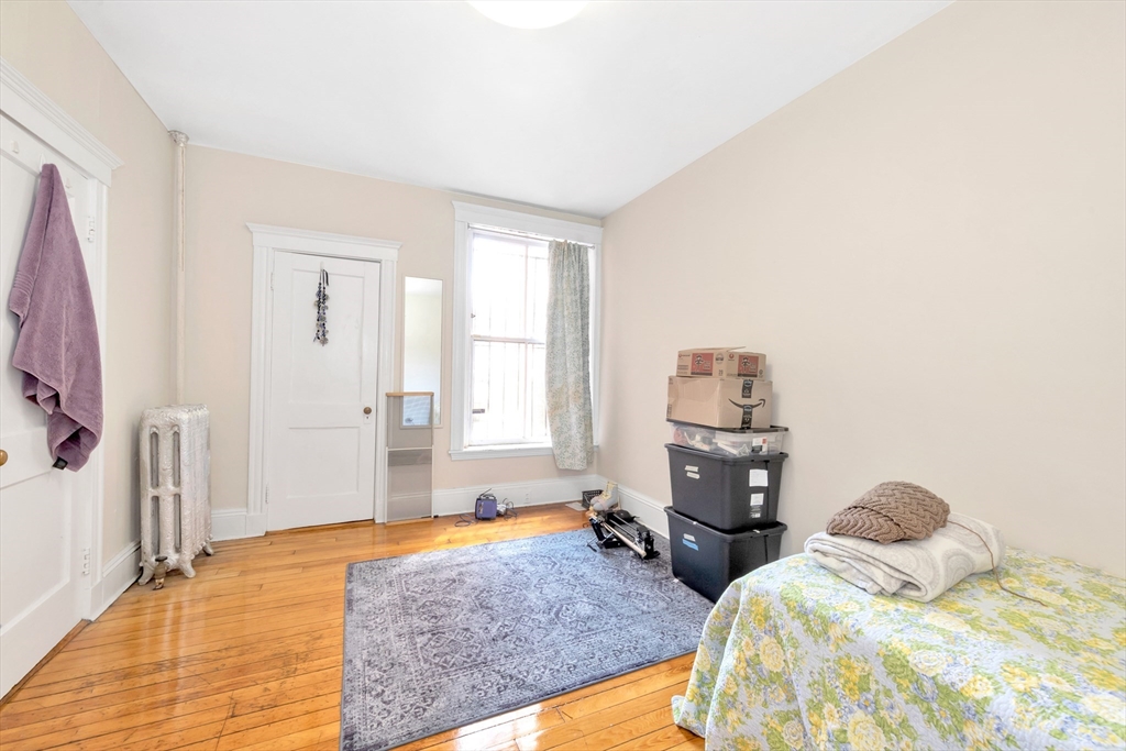 104 Strathmore Road Boston, MA 02135 - Photo 15 of 41 a bedroom with a bed and wooden floor