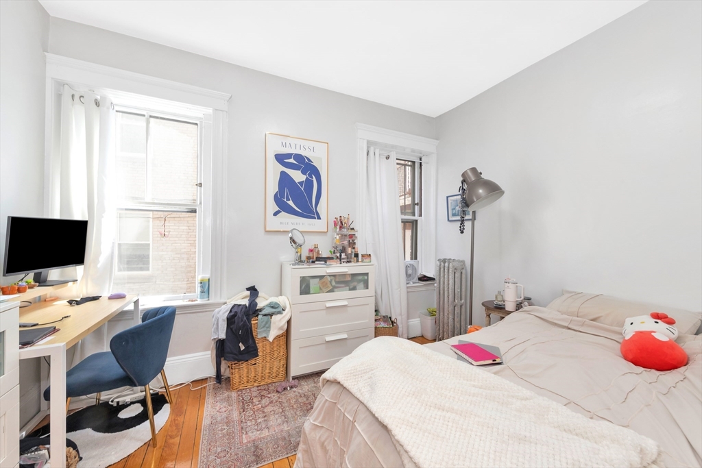 104 Strathmore Road Boston, MA 02135 - Photo 17 of 41 a bed room with a bed and a chair