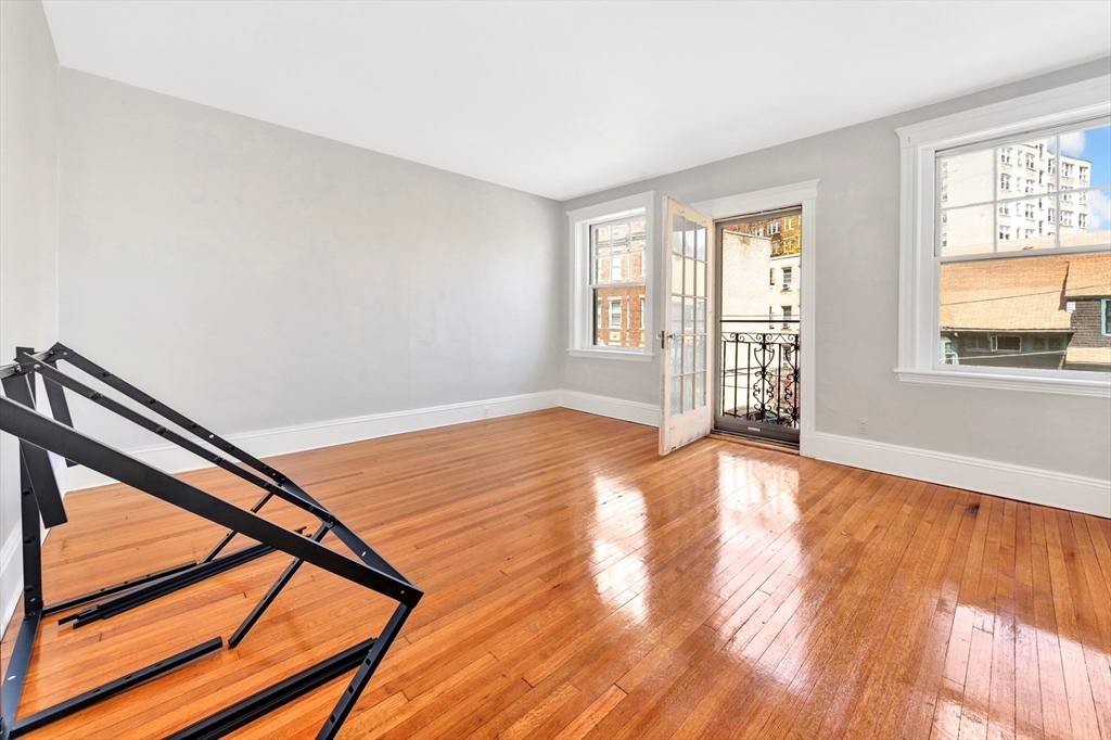 104 Strathmore Road Boston, MA 02135 - Photo 21 of 41 a view of an empty room with wooden floor and a window