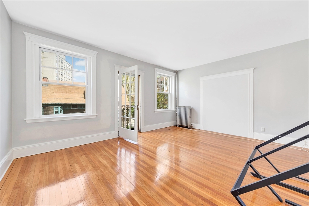 104 Strathmore Road Boston, MA 02135 - Photo 22 of 41 a view of an empty room with window and wooden floor