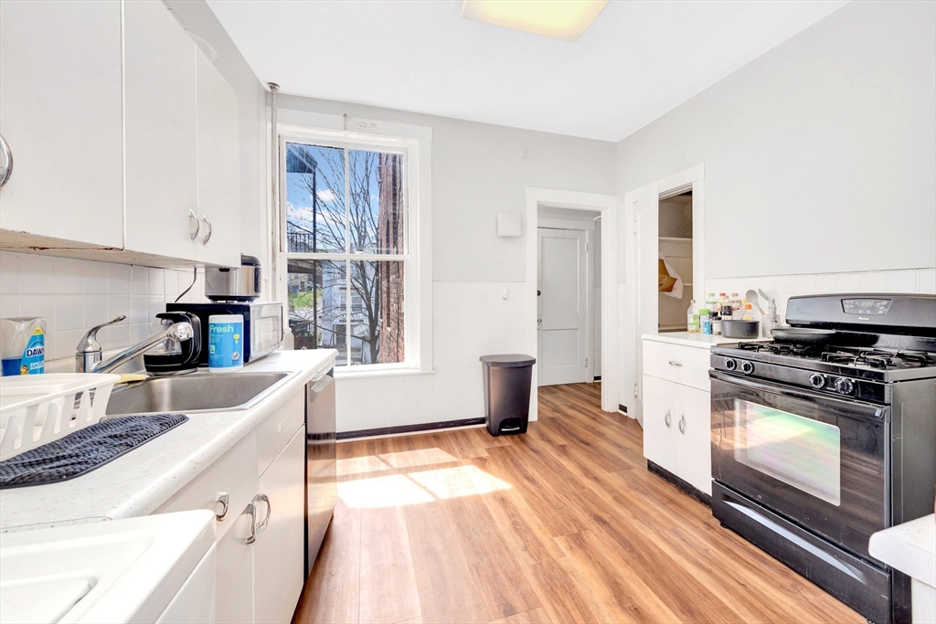 104 Strathmore Road Boston, MA 02135 - Photo 24 of 41 a kitchen with a stove a sink and a refrigerator