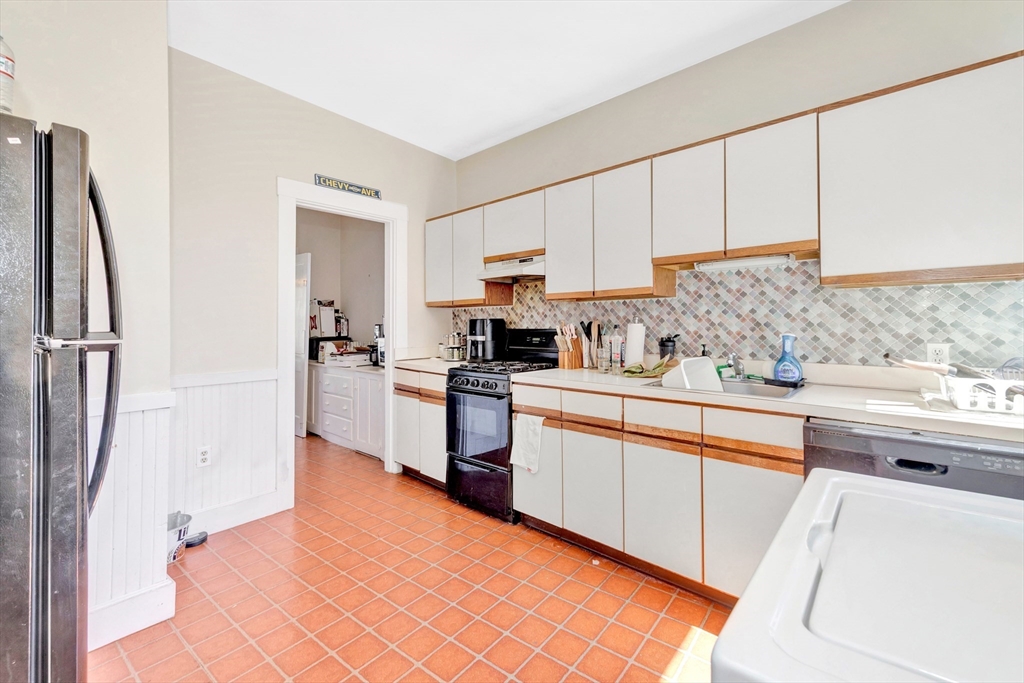104 Strathmore Road Boston, MA 02135 - Photo 36 of 41 a kitchen with stainless steel appliances granite countertop a refrigerator sink and white cabinets