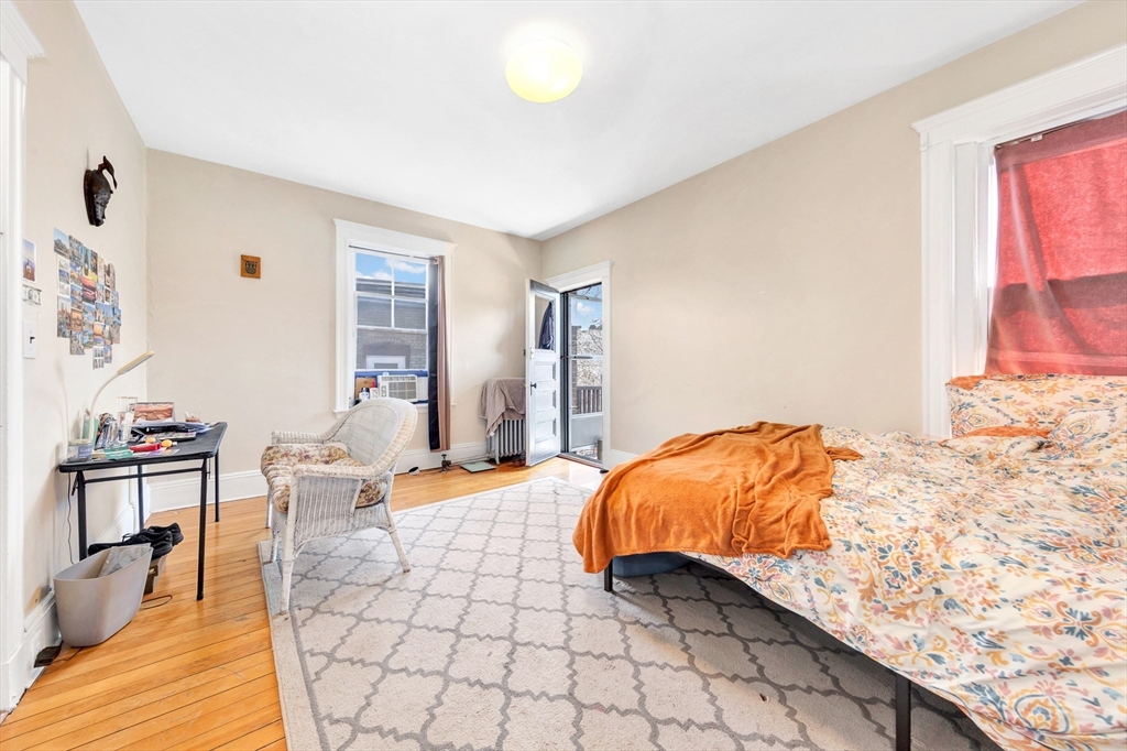 104 Strathmore Road Boston, MA 02135 - Photo 38 of 41 a bedroom with a bed and lamp with window
