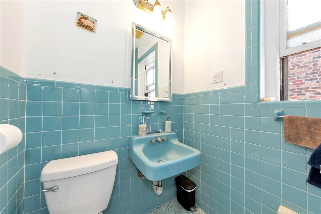 104 Strathmore Road Boston, MA 02135 - Photo 39 of 41 a bathroom with a toilet a sink and mirror