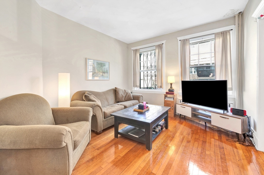 104 Strathmore Road Boston, MA 02135 - Photo 5 of 41 a living room with furniture a flat screen tv and a large window