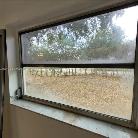 a view of a glass door with a yard from a window