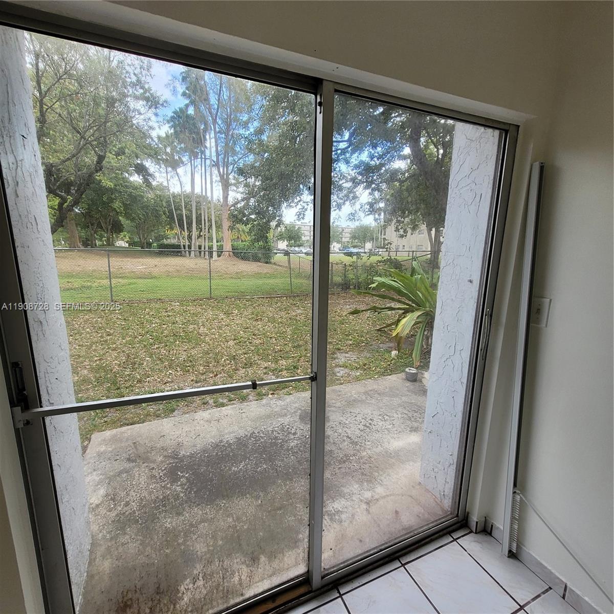 8540 Sherman Circle North, Unit 101 Miramar, FL 33025 - Photo 27 of 36 a view of a glass door with a yard from a window