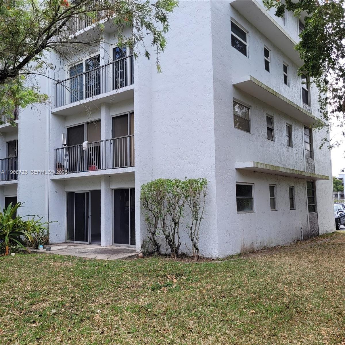 8540 Sherman Circle North, Unit 101 Miramar, FL 33025 - Photo 34 of 36 a view of a house with potted plants and a yard