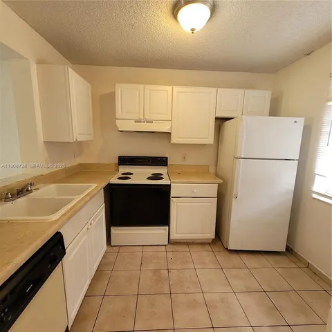 a kitchen with a sink a stove and a refrigerator