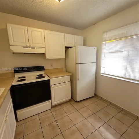 a white refrigerator freezer and a stove in a kitchen