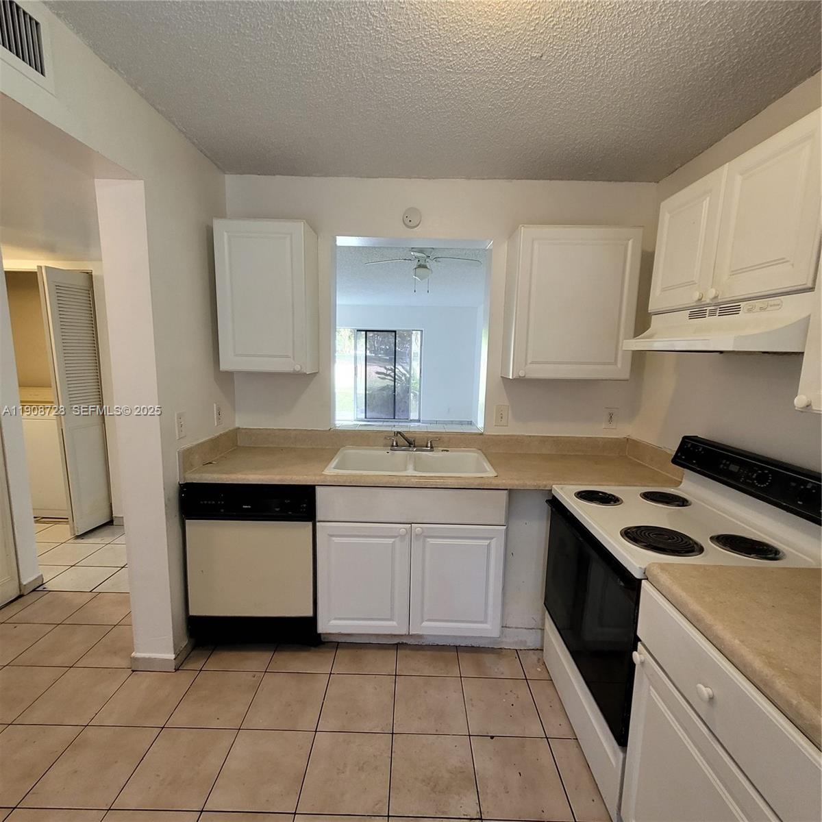 8540 Sherman Circle North, Unit 101 Miramar, FL 33025 - Photo 10 of 36 a kitchen with a stove sink and cabinets