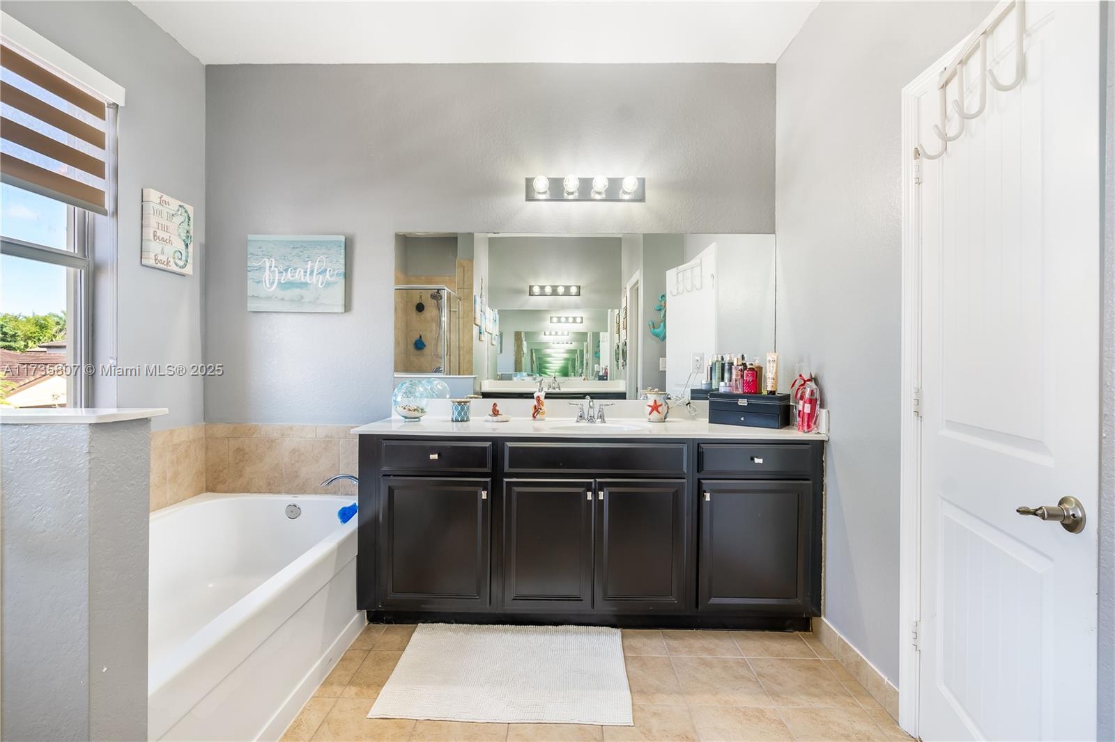 4170 Northeast 20th Street Homestead, FL 33033 - Photo 37 of 52 a spacious bathroom with a bathtub sink and mirror