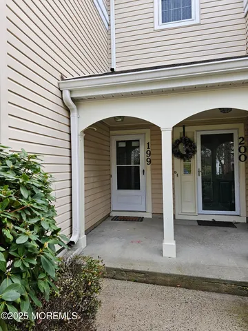 a view of a hallway with wooden floor and cabinet