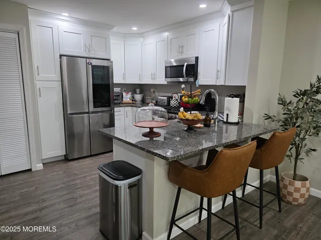 a kitchen with a dining table chairs and refrigerator