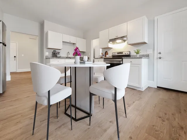 a kitchen with granite countertop white cabinets and stainless steel appliances