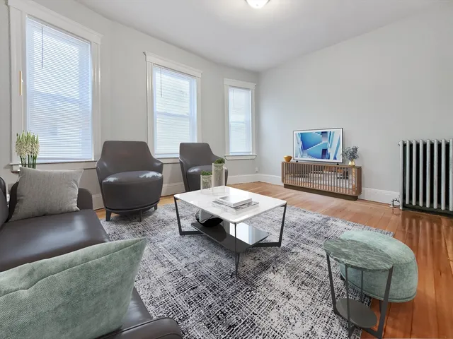 a living room with furniture a rug and a window