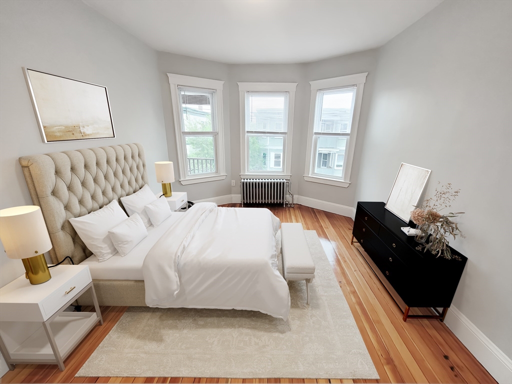 225 East Eagle Street, Unit 3 Boston, MA 02128 - Photo 8 of 10 a bedroom with a bed and wooden floor