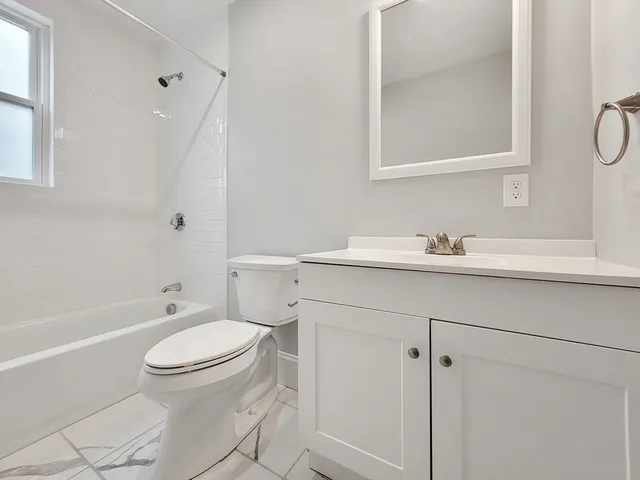 a bathroom with a sink toilet vanity and tub