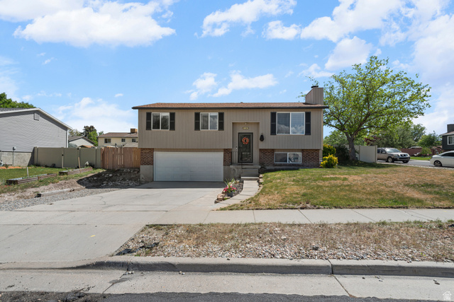 3951 Brixton Road Salt Lake City, UT 84129 - Photo 2 of 22 Split-level residence featuring a two-car garage and brick accents on the lower facade