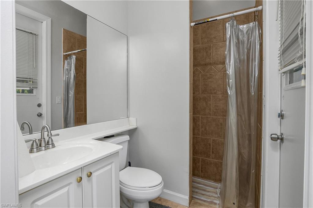 6175 Green Boulevard Naples, FL 34116 - Photo 13 of 20 a bathroom with a sink a toilet and shower