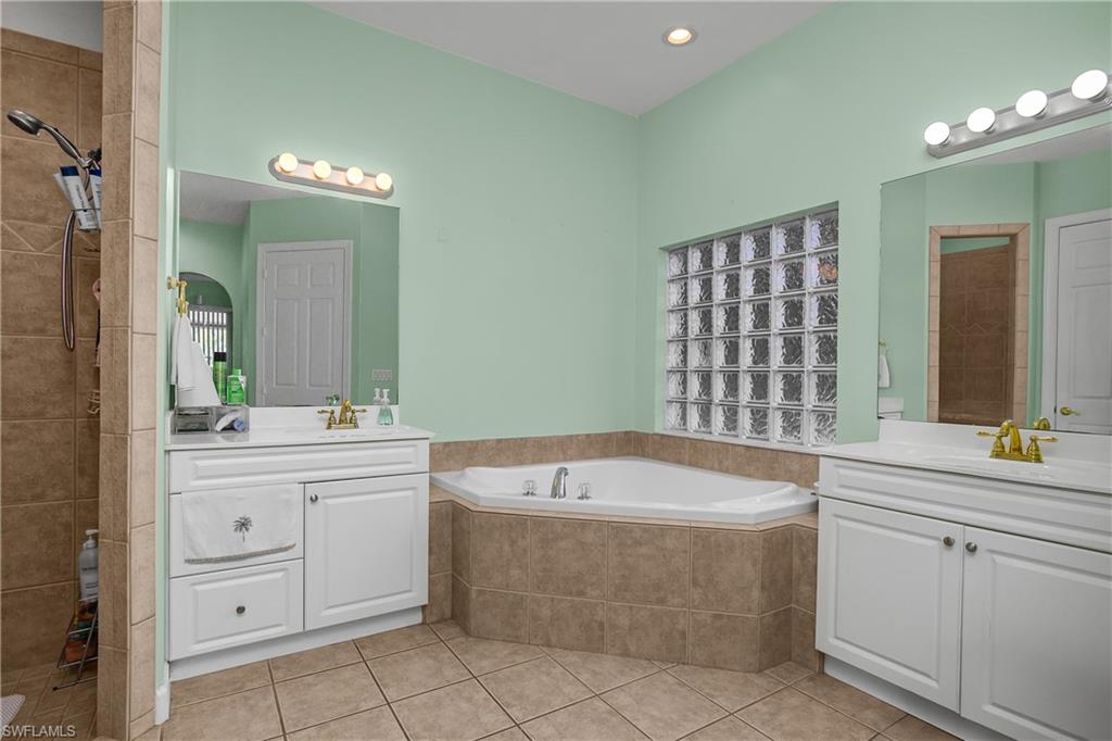 6175 Green Boulevard Naples, FL 34116 - Photo 9 of 20 a bathroom with a bathtub sink and mirror