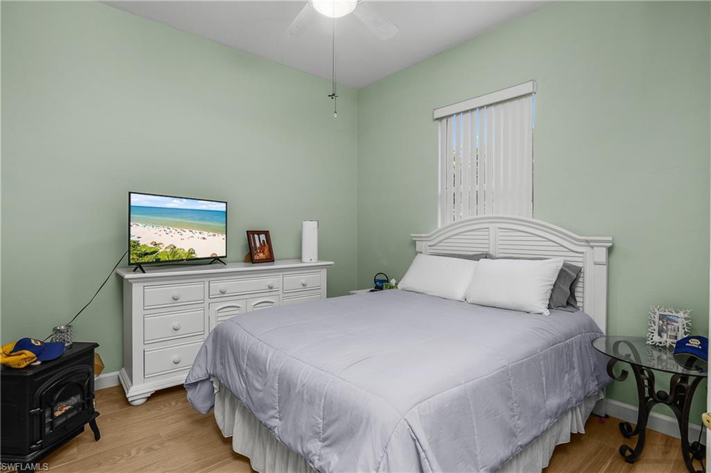 6175 Green Boulevard Naples, FL 34116 - Photo 10 of 20 a bedroom with a bed and a tv on the dresser