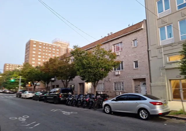a view of a cars park in front of a building