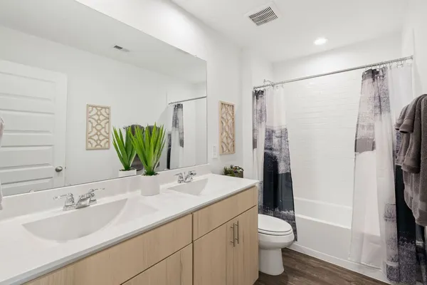a bathroom with a double vanity sink toilet and shower
