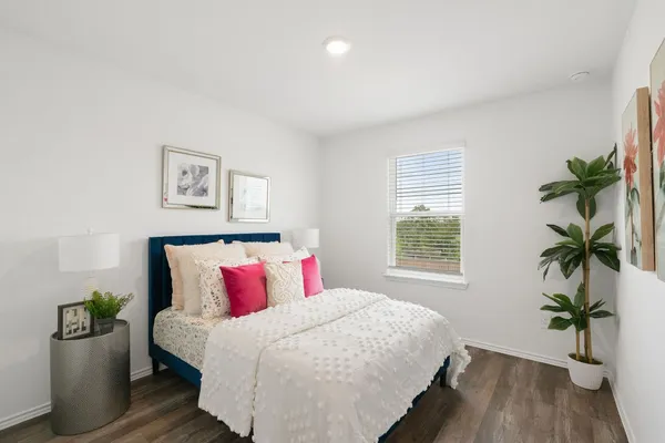 a bedroom with a bed and a potted plant