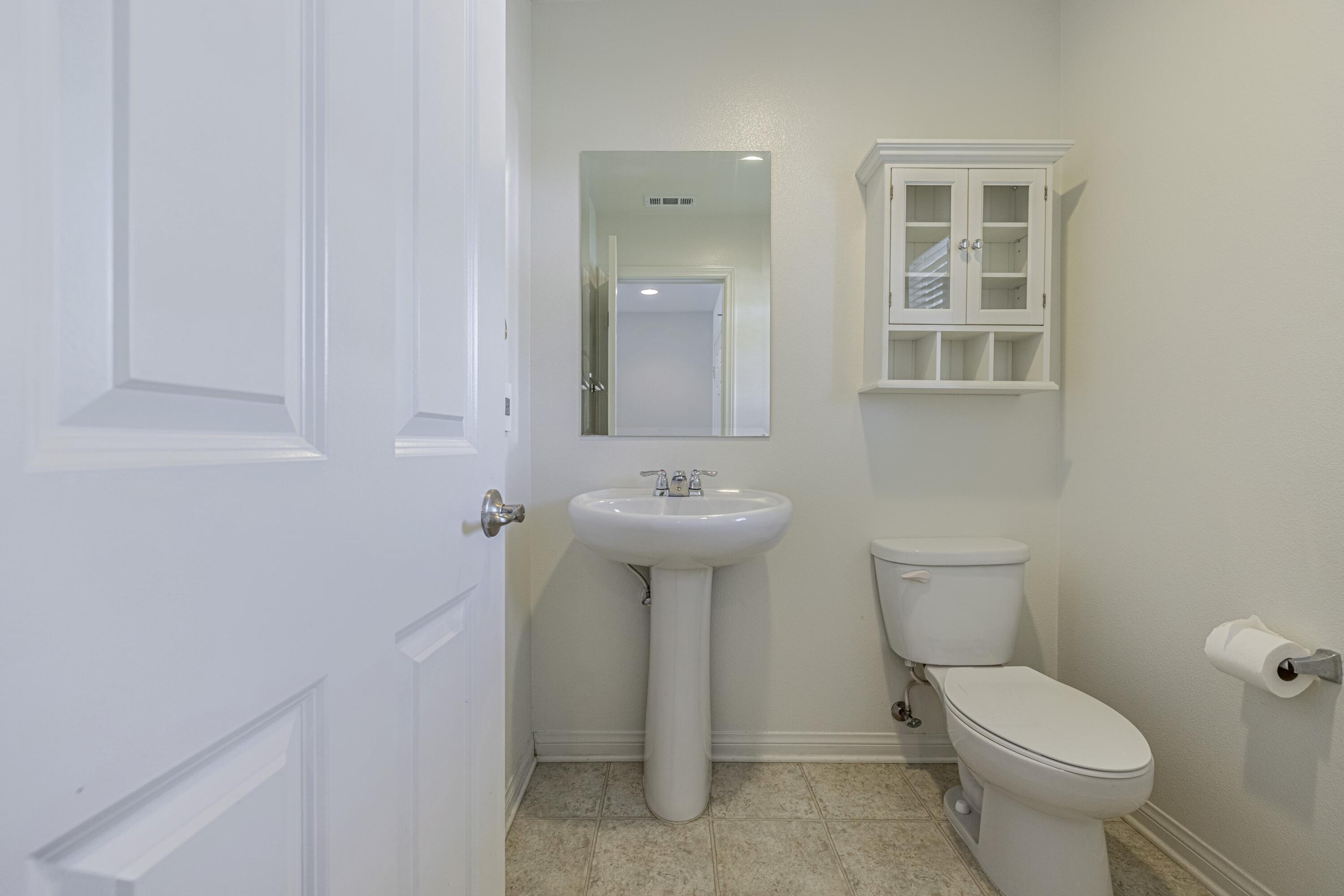 2732 Hemlock Road Palmdale, CA 93551 - Photo 11 of 42 a bathroom with a toilet a sink and mirror