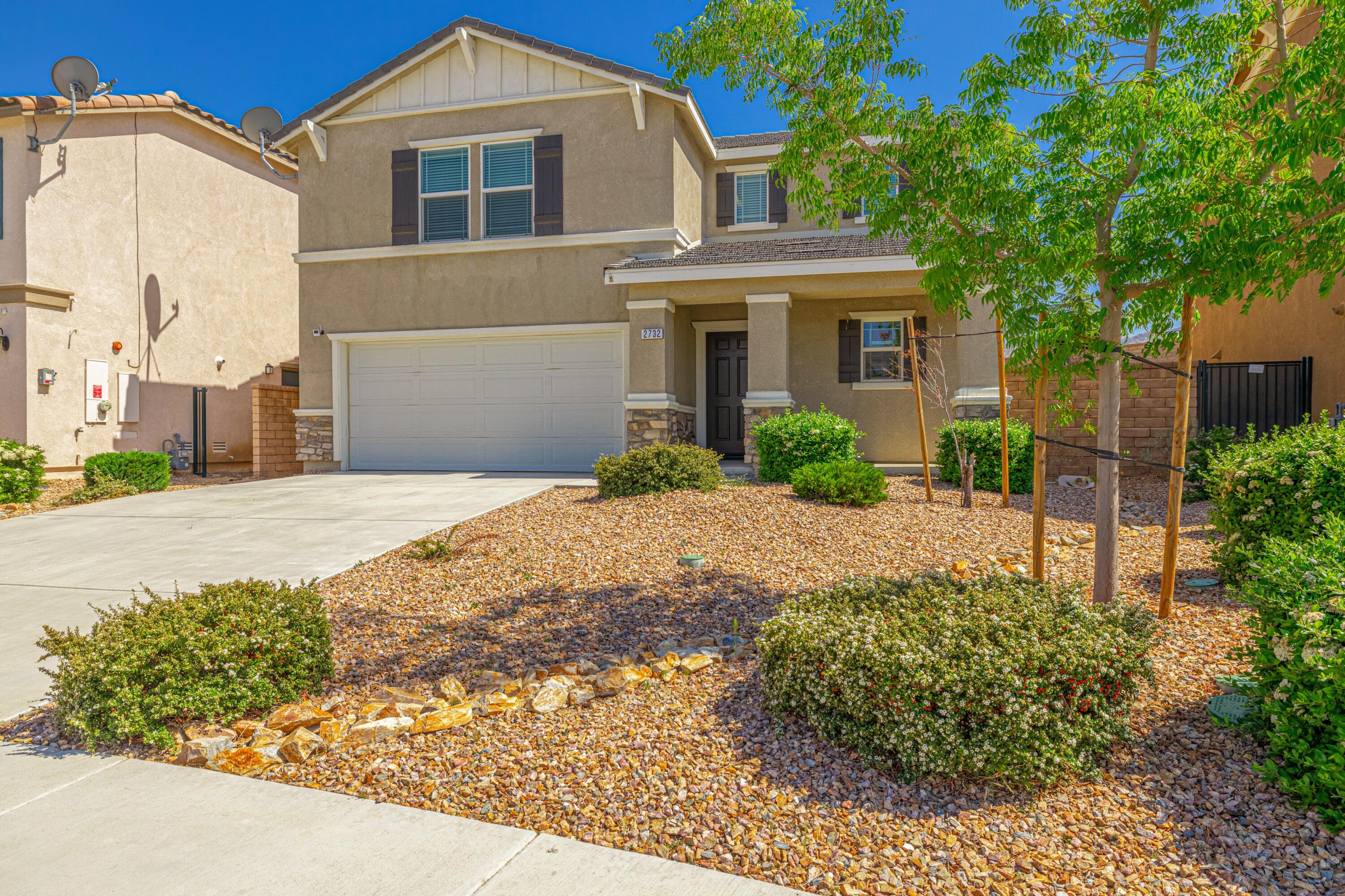 2732 Hemlock Road Palmdale, CA 93551 - Photo 3 of 42 a front view of a house with a garden