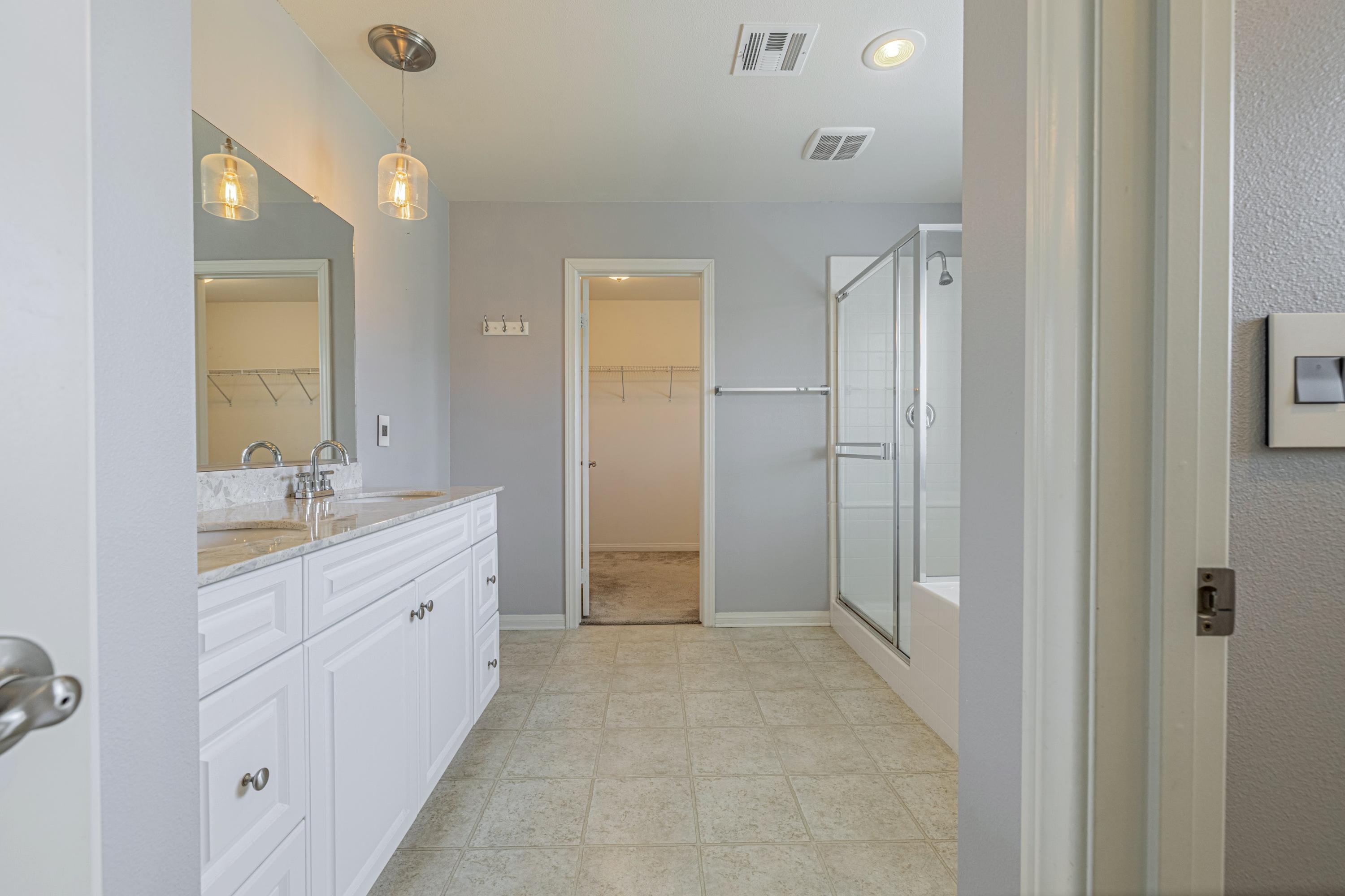 2732 Hemlock Road Palmdale, CA 93551 - Photo 27 of 42 a bathroom with a double vanity sink a mirror and a shower