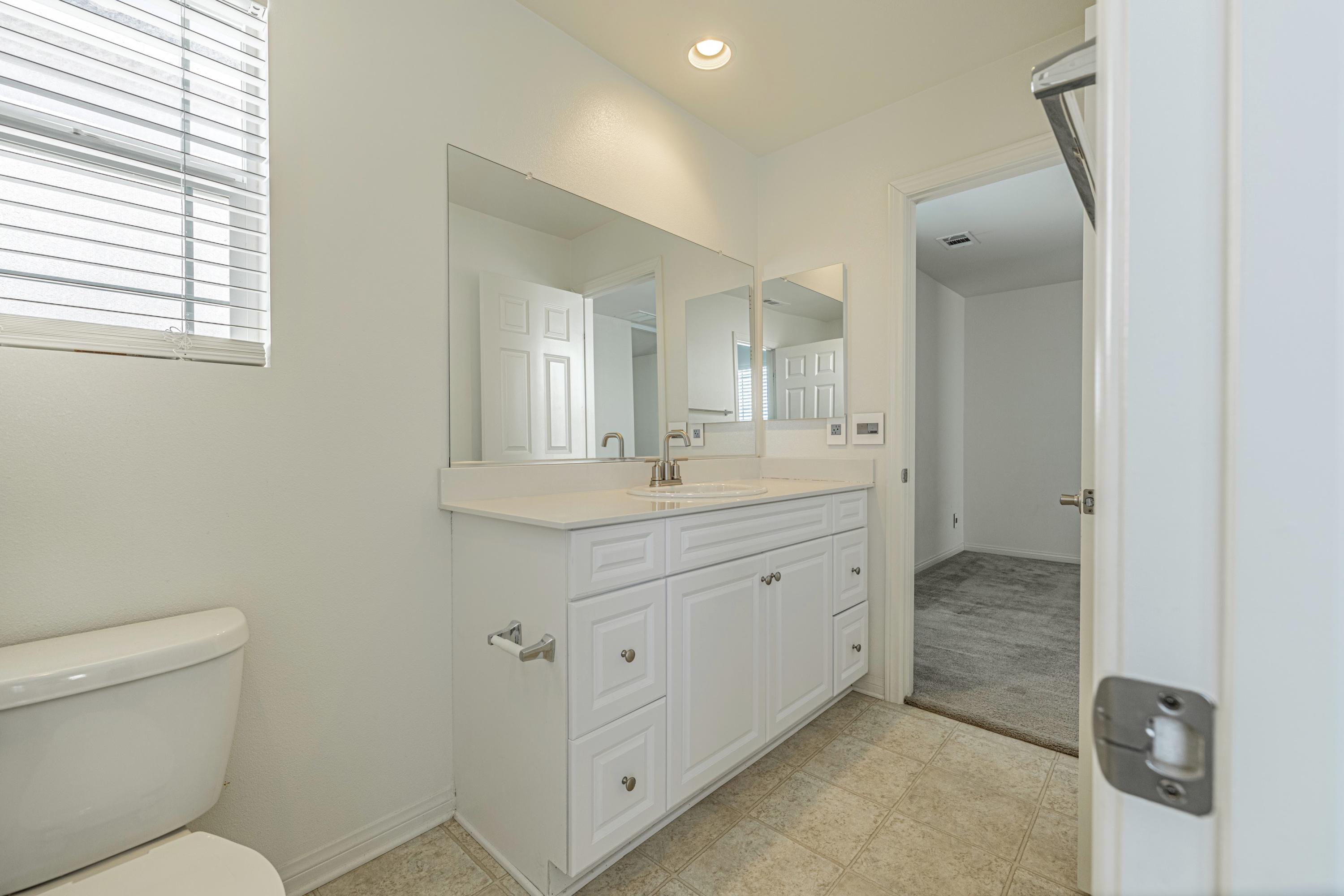 2732 Hemlock Road Palmdale, CA 93551 - Photo 28 of 42 a spacious bathroom with a granite countertop sink a toilet and a mirror