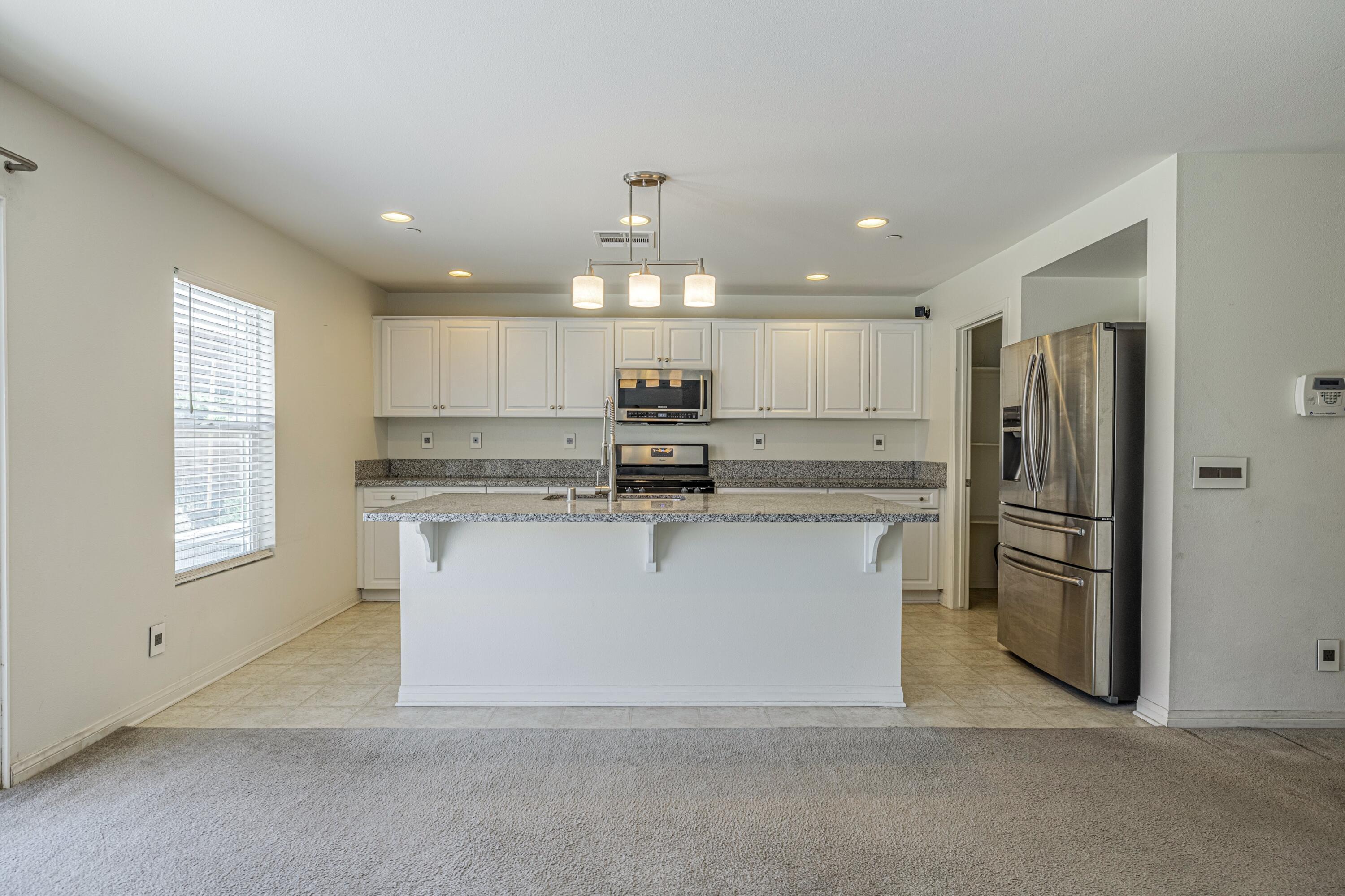 2732 Hemlock Road Palmdale, CA 93551 - Photo 7 of 42 a view of kitchen with stainless steel appliances granite countertop a stove a sink dishwasher and a refrigerator with wooden floor