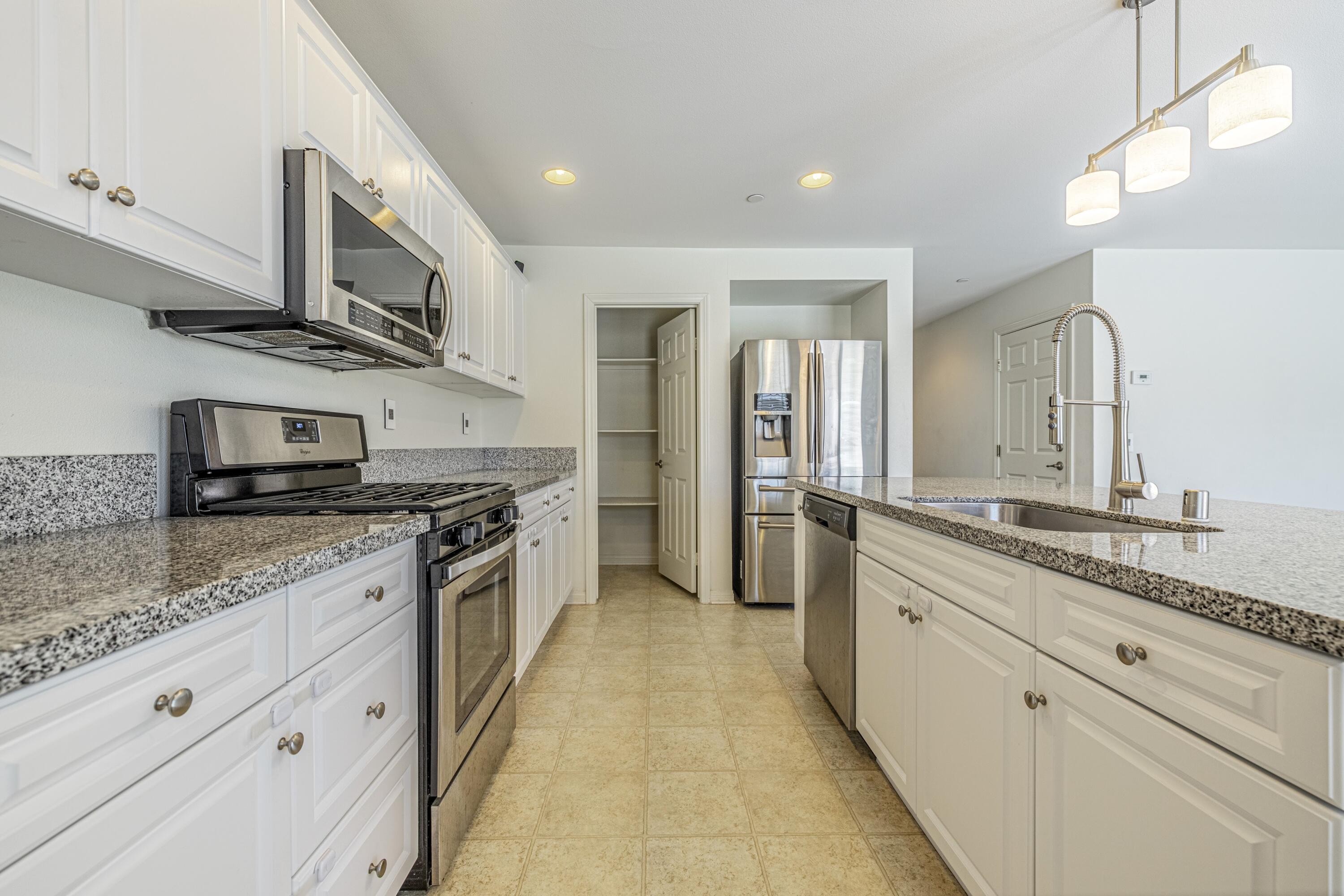 2732 Hemlock Road Palmdale, CA 93551 - Photo 10 of 42 a large kitchen with stainless steel appliances granite countertop a lot of counter space and a sink