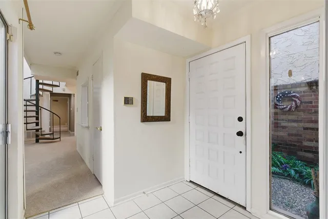 a view of a hallway with closet and a chandelier fan