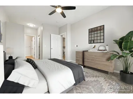 a bedroom with a bed a couch and potted plant