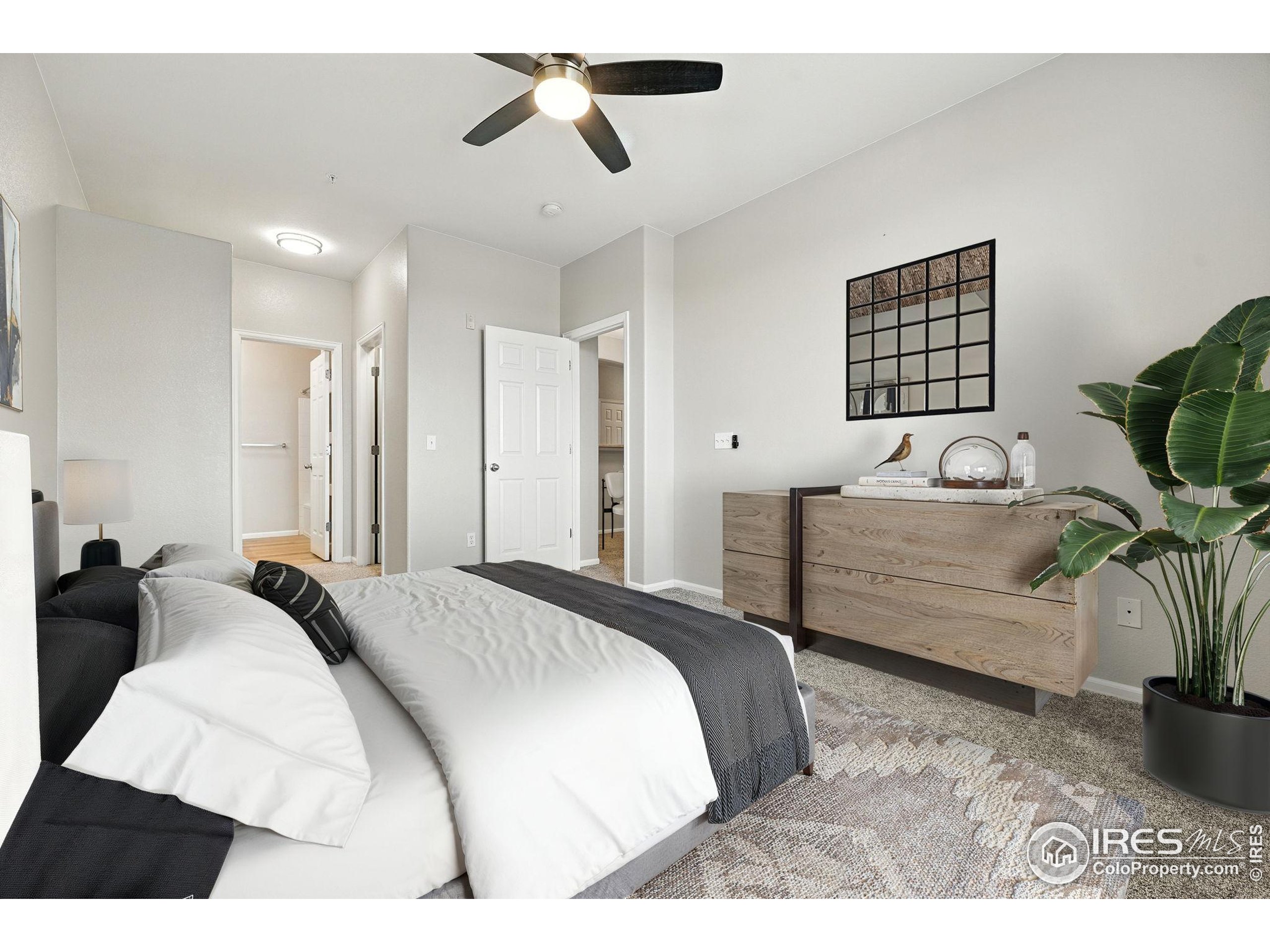 5255 Memphis Street, Unit 312 Denver, CO 80239 - Photo 13 of 44 a bedroom with a bed a couch and potted plant