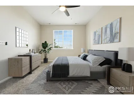 a spacious bedroom with a bed a couch and windows