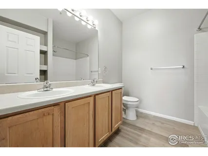 a bathroom with a granite countertop sink toilet a large mirror and a vanity