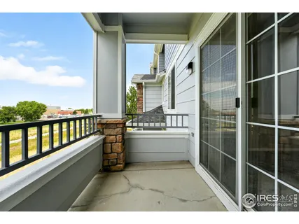 a view of an empty room with kitchen and fireplace