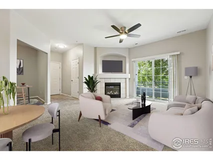a living room with furniture a fireplace and a large window