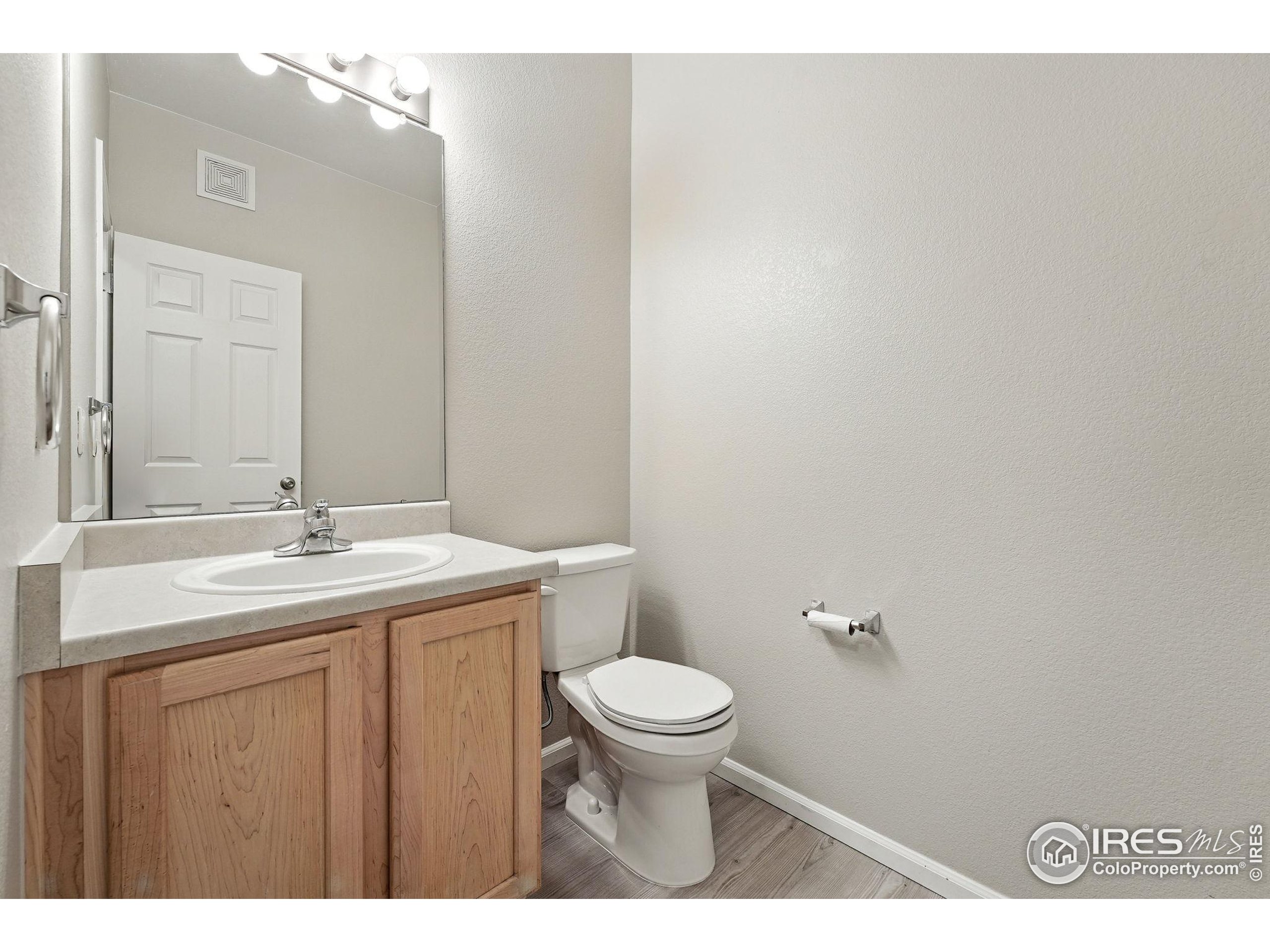 5255 Memphis Street, Unit 312 Denver, CO 80239 - Photo 34 of 44 a bathroom with a granite countertop toilet a sink and a mirror